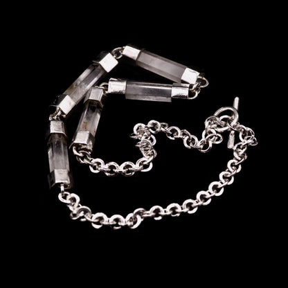 Close-up detail of handmade sterling silver and natural clear quartz crystal bar necklace, showing individual crystal bars set in hand-fabricated silver end caps, connected with jump rings, with handmade belcher chain visible, Thornhill Jewellery