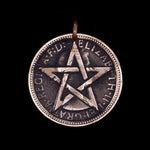Copper Penny coin pendant engraved with star on dark background, modern interpretation of trench art.