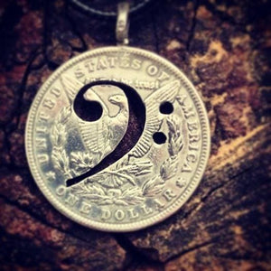Bass clef, American silver dollar cut Coin Pendant displayed on the dark  background